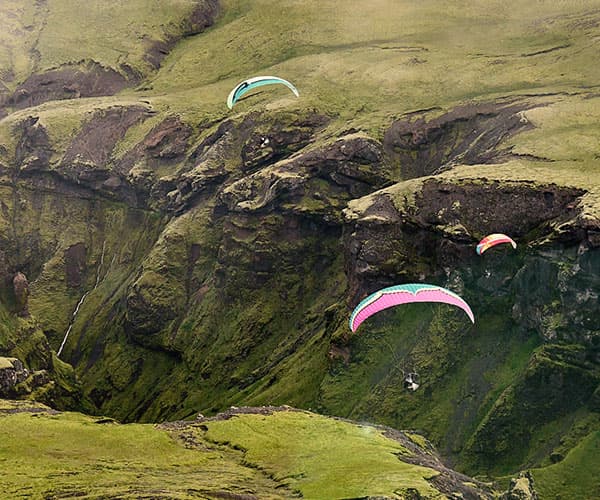 Paramotor pilot flying over scenic Iceland landscape
